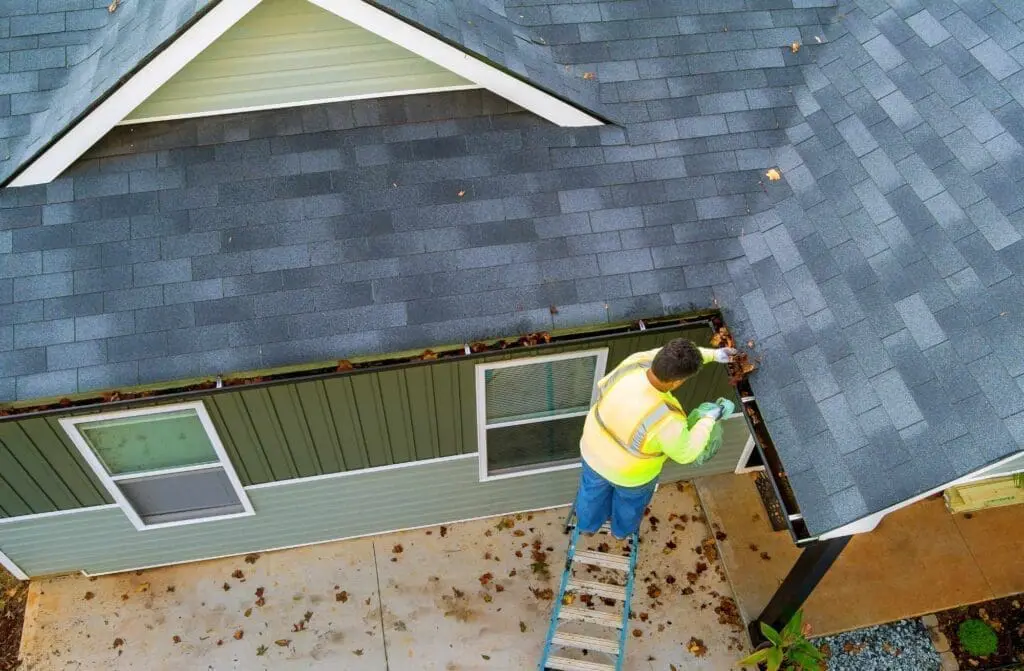 a worker making sure there are no gutter problems