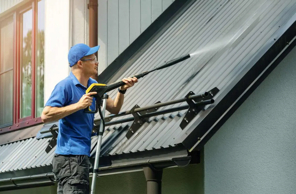 a roofing professional cleaning a standing seam metal roof