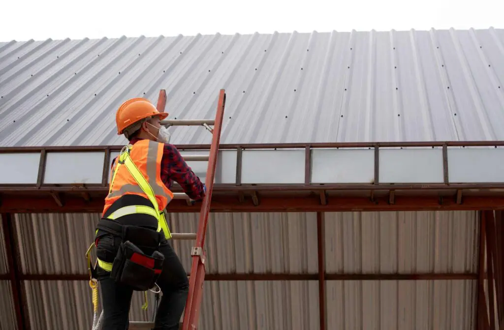 a roofer preparing to inspect metal panel seams