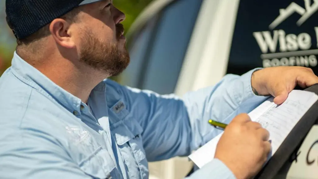 a roofer inspecting metal roofing and calculating the labor costs