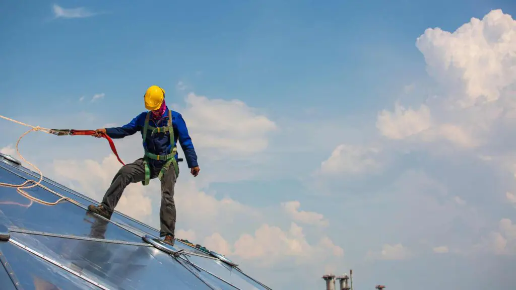 a roofer wearing a safety harness