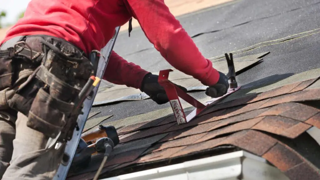 a roofer installing new shingles on a leaking roof