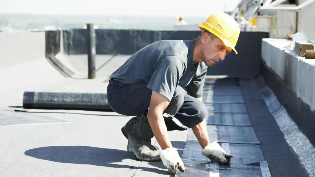 a roofer working on the substrate and fasteners on a roof