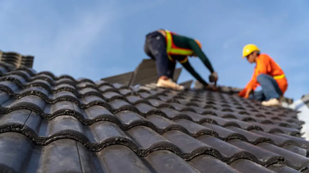roofers installing tile on every square foot of a roof