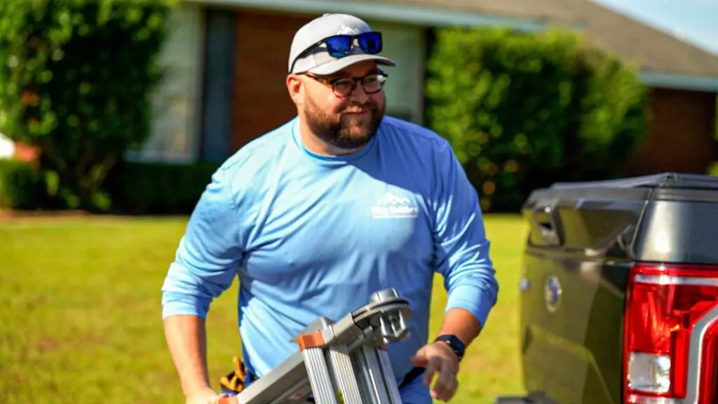 a roofer preparing to inspect the siding of a home