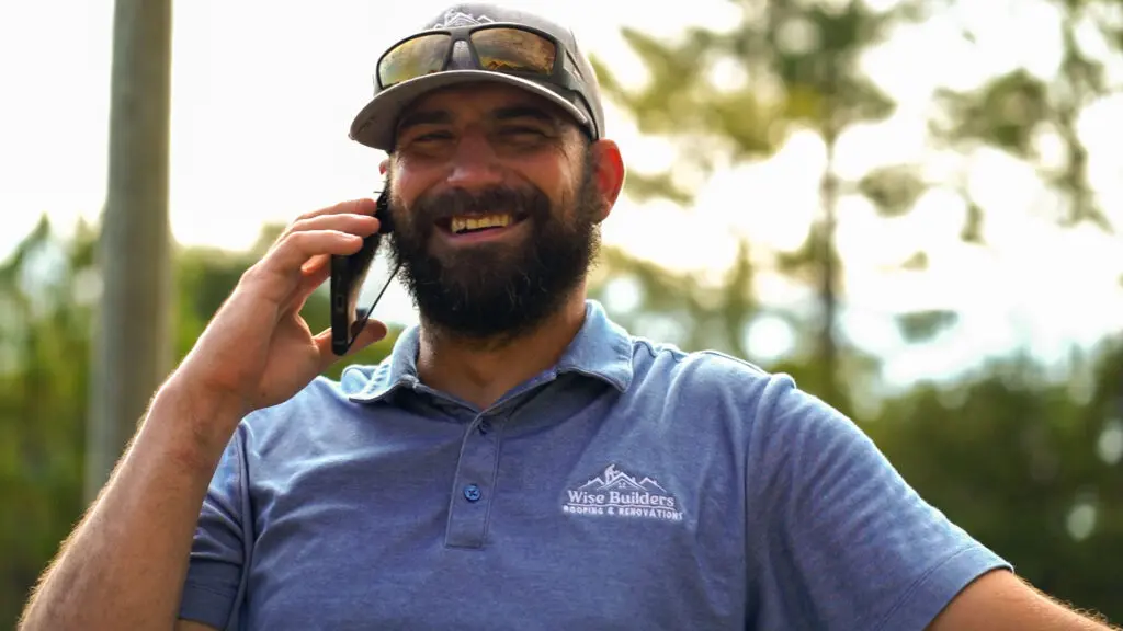 a roofer from wise builders roofing and renovations on the phone with a metal roof customer
