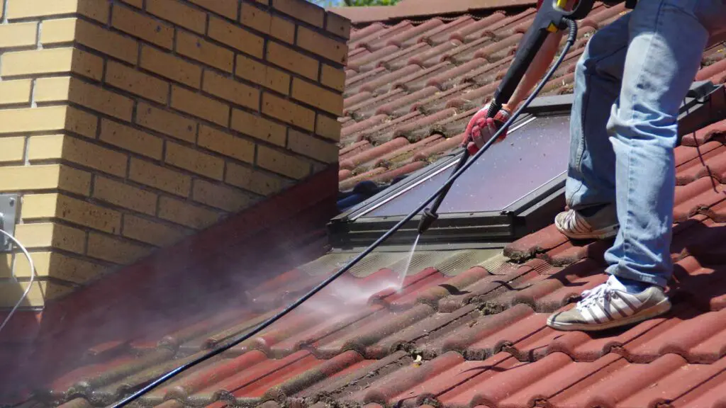 using a pressure washer to clean a roof