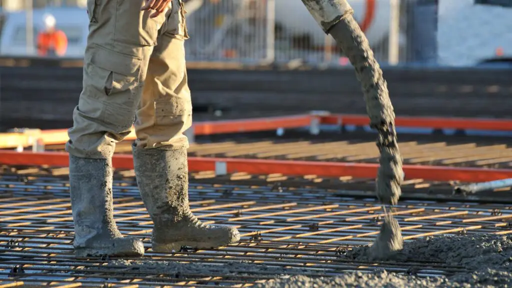 a worker pouring concrete to provide structural support