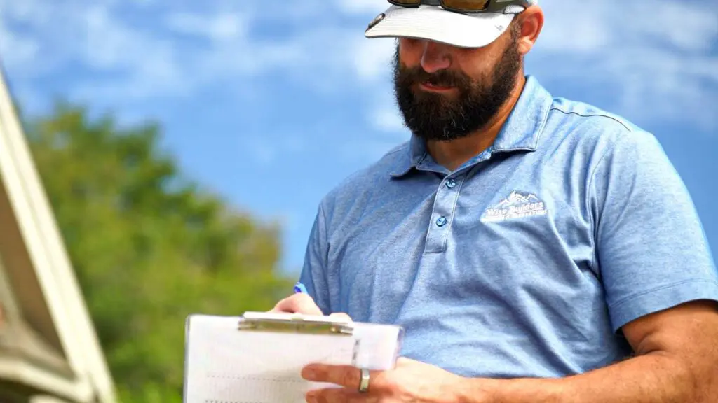 a roofer calculating the cost of materials on a notepad