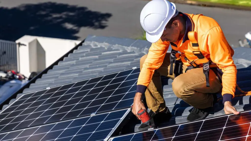a roofing expert installing solar panels on a home