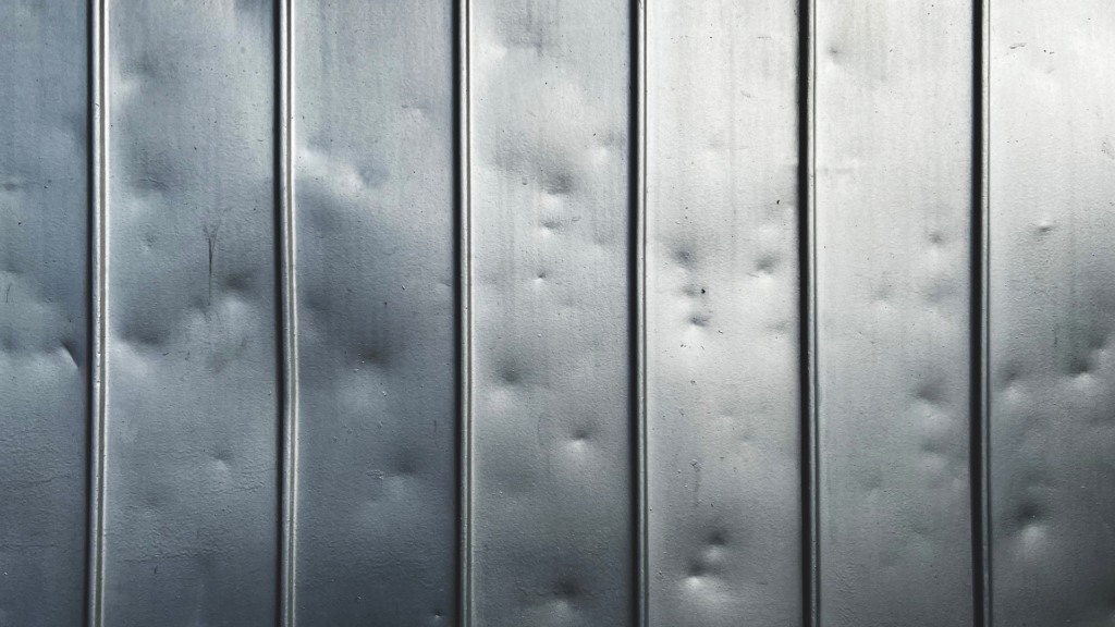 a metal panel with dents from hail damage