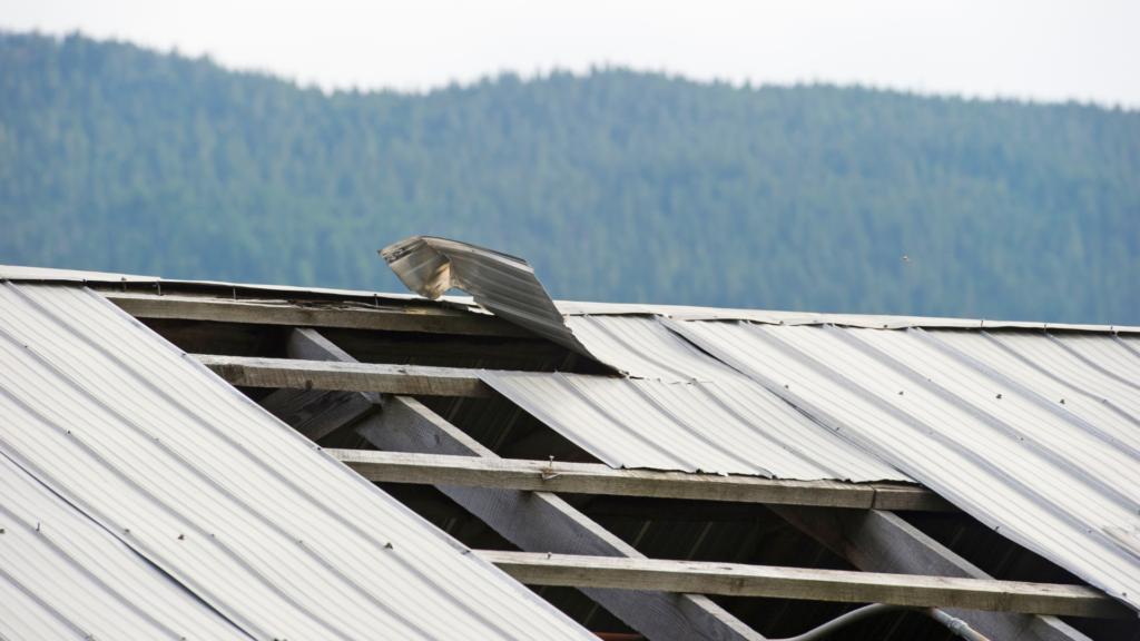 a metal roof with metal panels missing due to storm damge