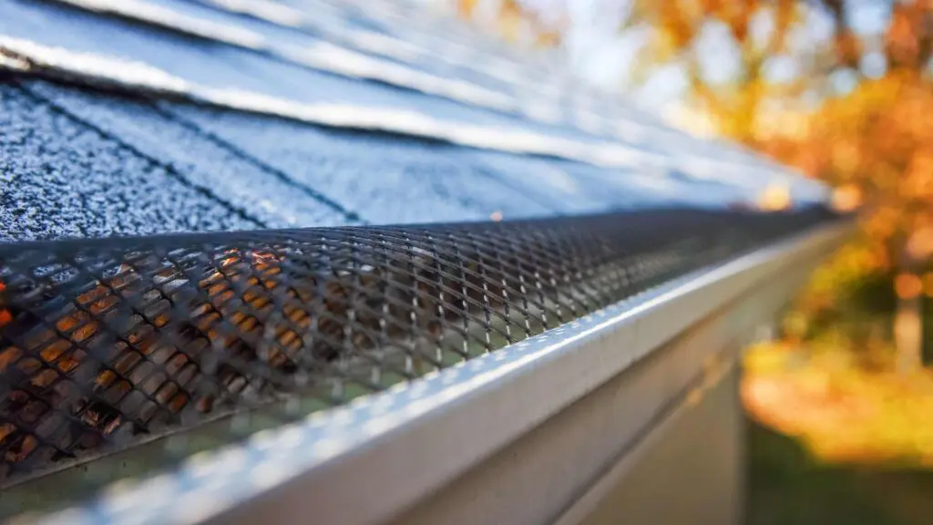 a close up image of a silver gutter with a gutter guard on it