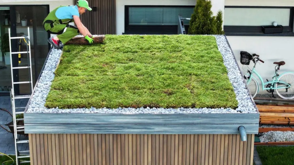 a roofer installing a green roof on top of a small building