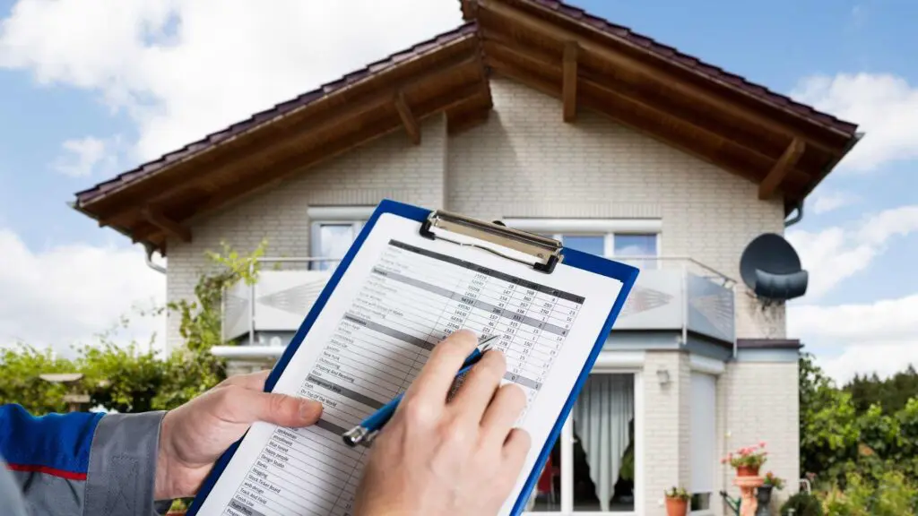 a man holding a clipboard containing a home insurance policy. in front of a home
