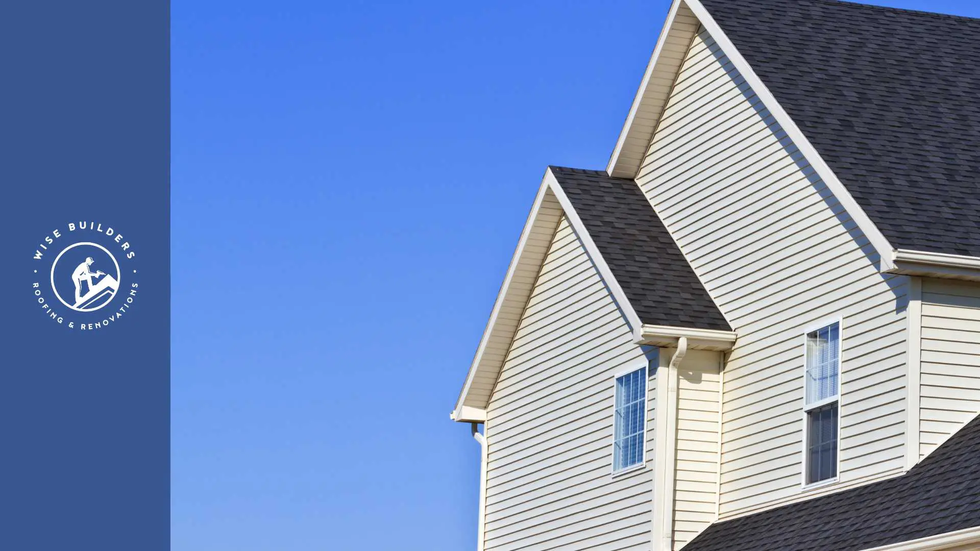a home with tan vinyl siding and black roof