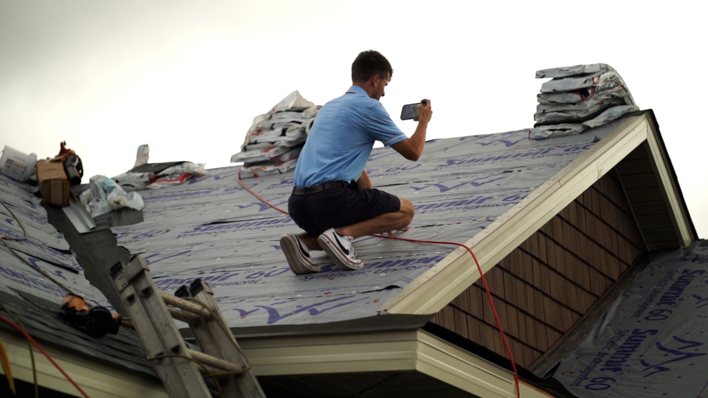 a roofer taking photos of a new roof that is being installed in alabama