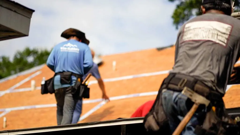 roofers working on a roof replacement that has been replaced by the insurance company