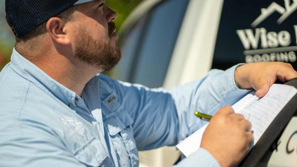 a roofer inspecting metal roofing and calculating the labor costs