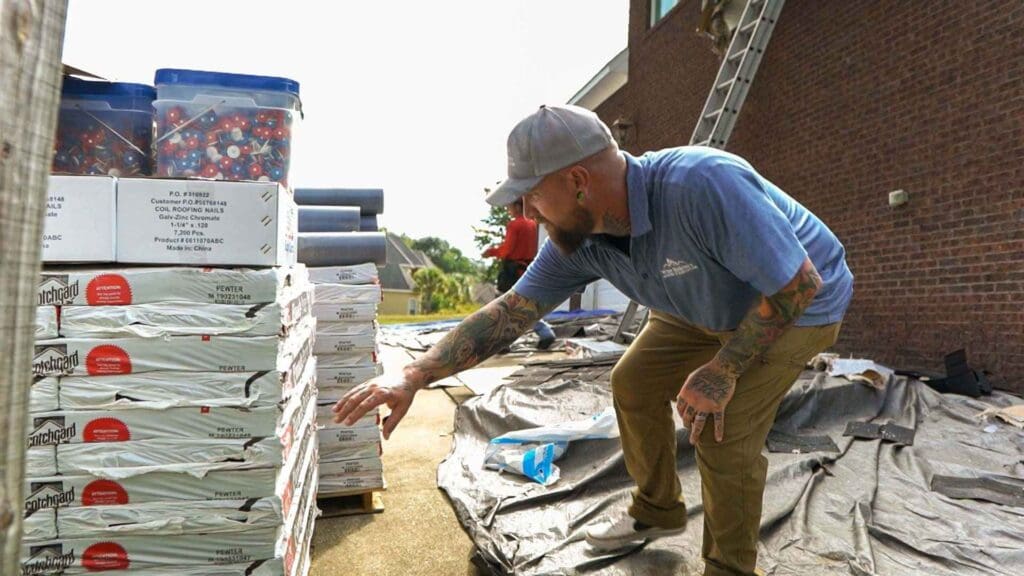 a project manager from Wise Builders counting the asphalt shingles for a roof replacment