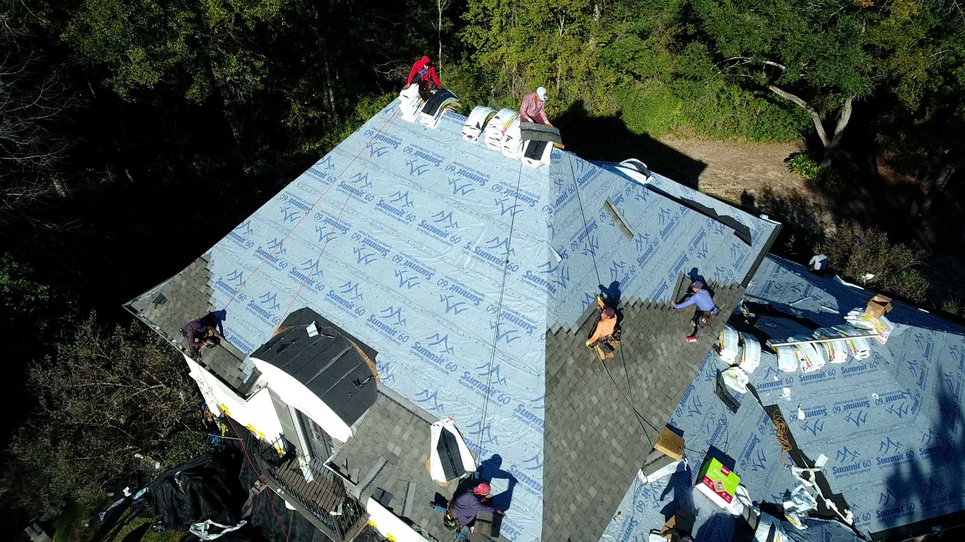 a roofing crew from the roofing company wise builders installing a new roof on a home.